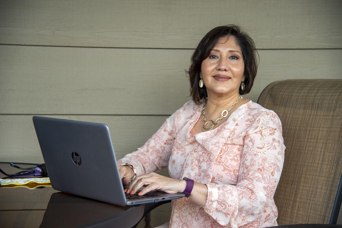 Damaris Aragon, a mental health nurse practitioner in private practice, often works on her laptop on the patio of her home, shown April 30 in north Spokane. She mostly meets patients over remote connections these days. (Jesse Tinsley / The Spokesman-Review)