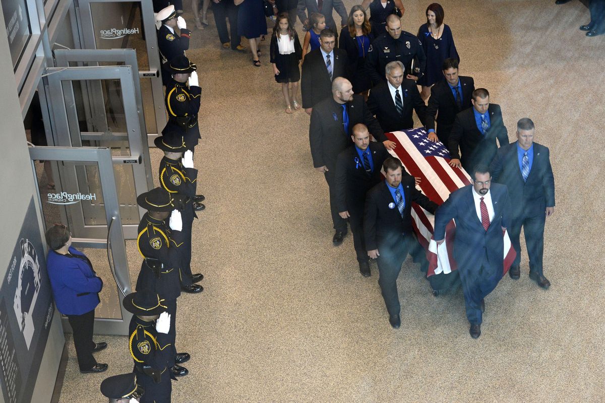 The casket of Baton Rouge Police officer Matthew Gerald is wheeled out of the Healing Place Church during his funeral in Baton Rouge, La., Friday, July 22, 2016. Top right is his widow Dechia Gerald. More than 2,000 people packed the church where Mayor Kip Holden and other leaders eulogized Gerald, the first of three officers slain by a lone gunman to be laid to rest (Bill Feig / Associated Press)