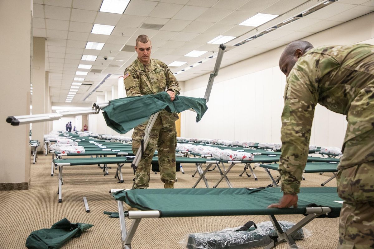 US Army National Guard Pvt. Christopher Zambuto, left, and Specialist Jermaris Hamilton assemble cots in a shelter for Hurricane Dorian evacuees inside the old Sears location at Northgate Mall, on Wednesday, Sep. 4, 2019, in Durham, NC. (Casey Toth / associated press)