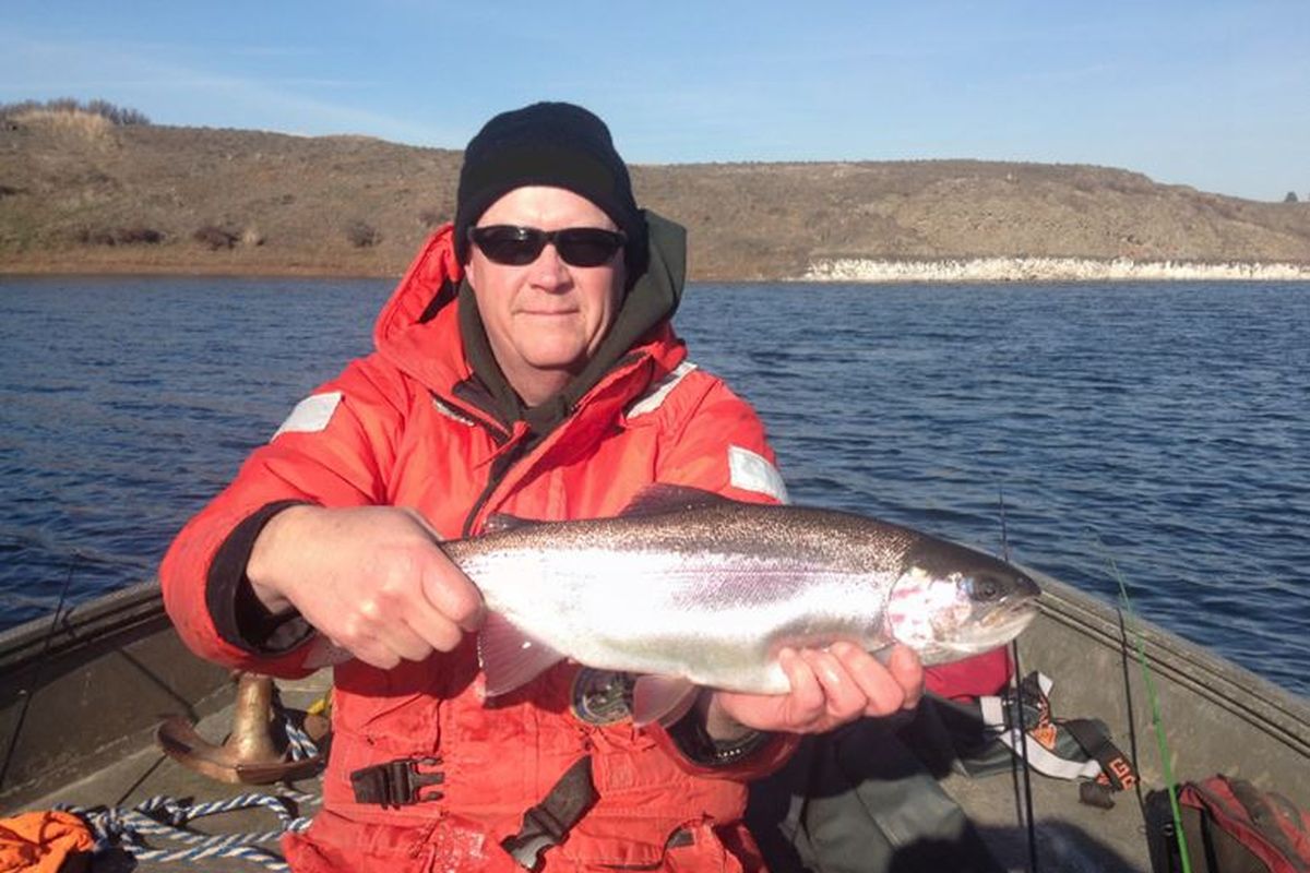 State fisheries biologist Randy Osborne holds a large rainbow caught in pre-season sampling at Fourth of July Lake south of Sprague.  (Washington Department of Fish and Wildlife)
