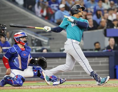 Mariners second baseman Jorge Polanco hits a three-run home run against the Blue Jays in Game 2 of the ALCS on Oct. 13 at Rogers Centre in Toronto.  (Jennifer Buchanan/Seattle Times)