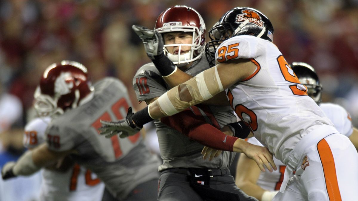 WSU QB Jeff Tuel gets a pass off and then is rocked by a hit from Oregon State defensive end Scott Crichton in Seattle. (Chirstopher Anderson)