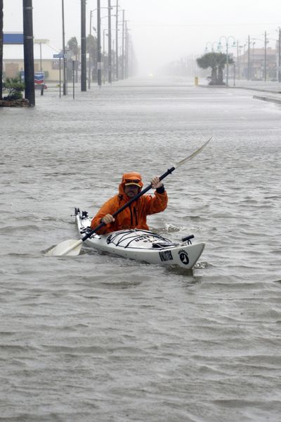 Dennis Barrett paddles his kayak down a flooded street in South Padre Island, Texas, on Wednesday. (Associated Press)
