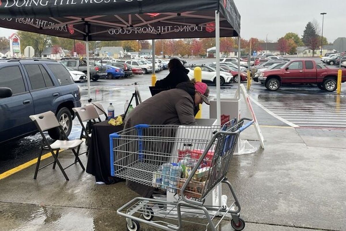 Tamara Apfelbeck, a Salvation Army volunteer, loads donated food items into a Salvation Army bin as part of the organization’s food drive Saturday at the Shadle Park Walmart in north Spokane.  (Garrett Cabeza / The Spokesman-Review)