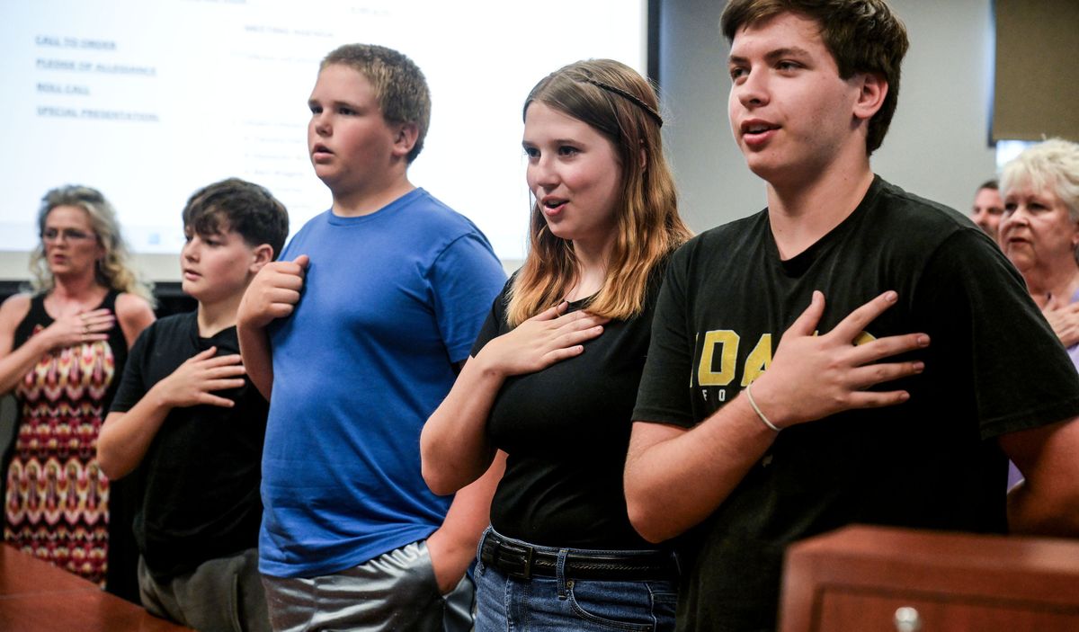 Tammy Hall, left, Weston Collins, Ethan Overby, Rae Overby and Ben Wagele recite the Pledge of Allegiance during a ceremony Monday at the Spokane Valley Fire Department administration building. They administered CPR and saved the life of a fellow swimmer and earned the SVFD Lifesaving Award.  (Kathy Plonka/The Spokesman-Review)