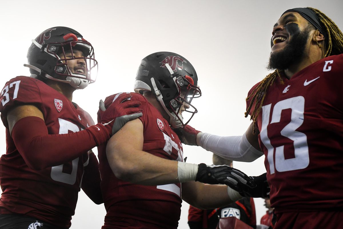 Washington State Cougars linebacker Justus Rogers (37) and linebacker Jahad Woods (13) mob running back Max Borghi (21) in celebration during the second half of a college football game on Friday, Nov 19, 2021, at Martin Stadium in Pullman, Wash. WSU won the game 44-18. Rogers and Woods now hold the record for most consecutive games played at WSU.  (Tyler Tjomsland/The Spokesman-Review)