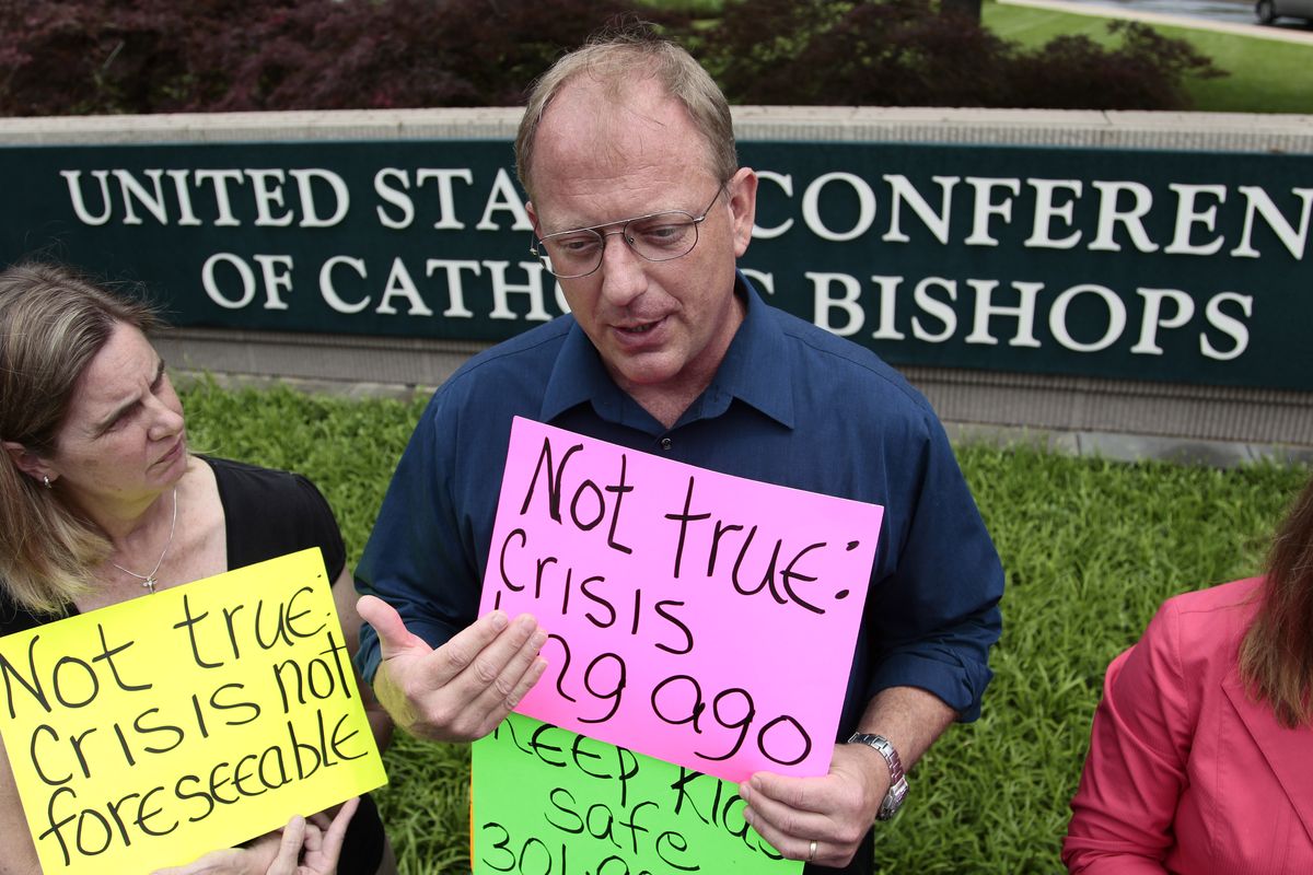 David Lorenz, center, and his wife Judy Lorenz, left, protest outside the headquarters of the US Conference of Catholic Bishops before the release of the findings of a study to analyze the pattern of clergy sex abuse, Wednesday, May 18, 2011, in Washington. The study, commissioned by the nation