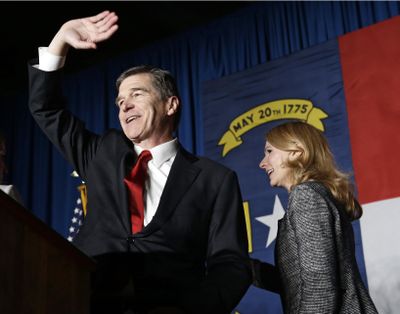 In a Wednesday, Nov. 9, 2016 file photo, North Carolina Democratic candidate for governor Roy Cooper and his wife Kristin greet supporters during an election night rally in Raleigh, N.C. (Gerry Broome / Associated Press)