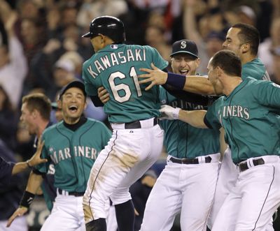 Seattle Mariners celebrate after Munenori Kawasaki scored winning run in bottom of ninth inning Monday night. (Associated Press)
