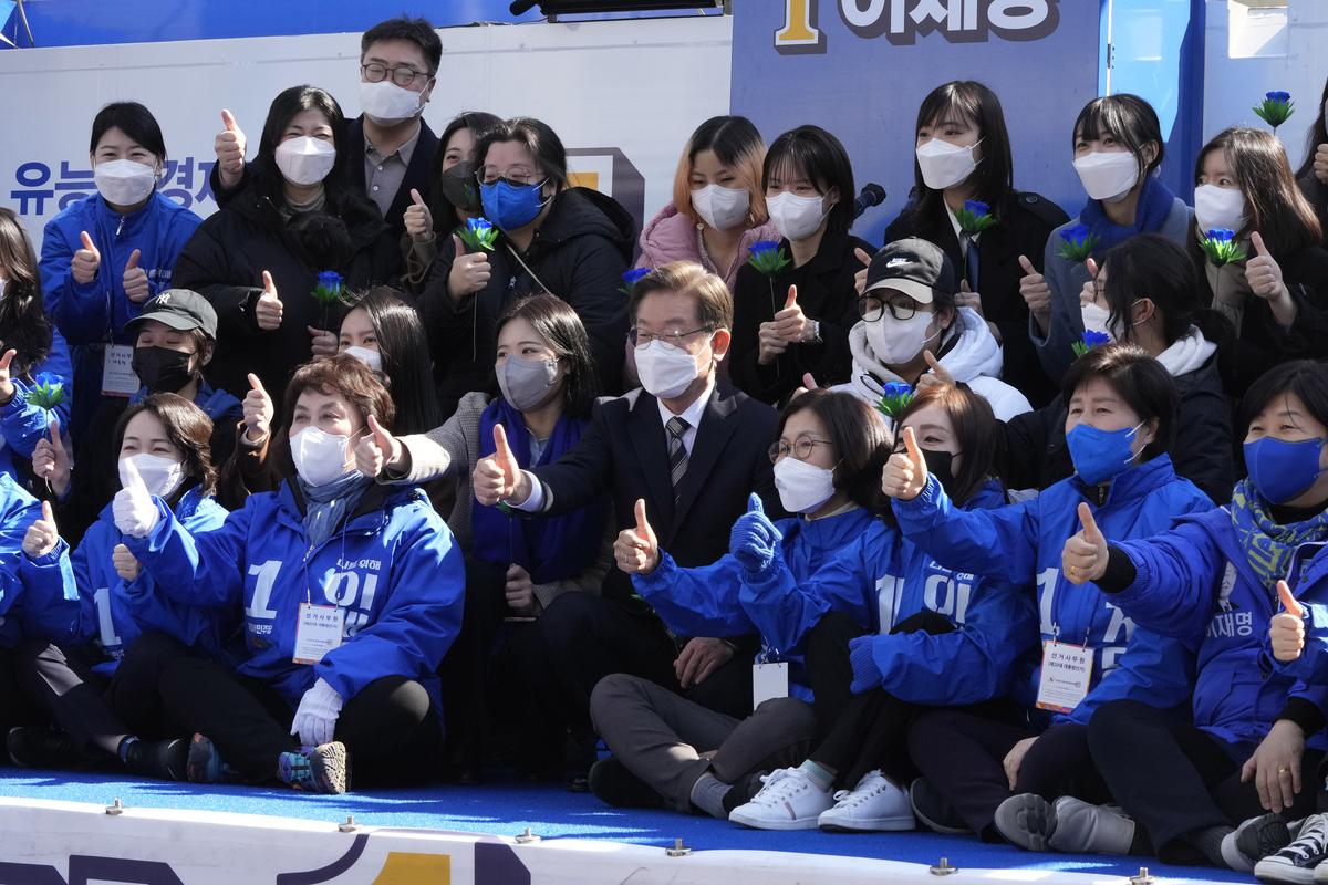 Lee Jae-myung, center, the presidential candidate of the ruling Democratic Party, poses with his supporters during a presidential election campaign in Seoul, South Korea on March 3, 2022. Just days before March 9 election, Lee and Yoon Suk Yeol from the main conservative opposition People Power Party are locked in an extremely tight race.. (Ahn Young-joon)