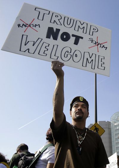 Michael Garcia of the Watsonville Brown Berets holds up a sign protesting Donald Trump outside of the Hyatt Regency hotel before the California Republican Party 2016 Convention in Burlingame, Calif., Friday. (Jeff Chiu / Associated Press)