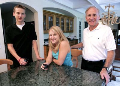 
Ted Schmidt stands with two of his four children, Noah, left, and Ciarra at their Burr Ridge, Ill., home. Schmidt uses cell phone GPS technology to keep track of his children, two of whom are now in college. While Ciarra, who is a college freshman, feels the phone is a security blanket and likes knowing her parents can find her in emergencies, Noah, 15, who's been caught a few places he wasn't supposed to be, isn't fond of it.
 (Associated Press / The Spokesman-Review)