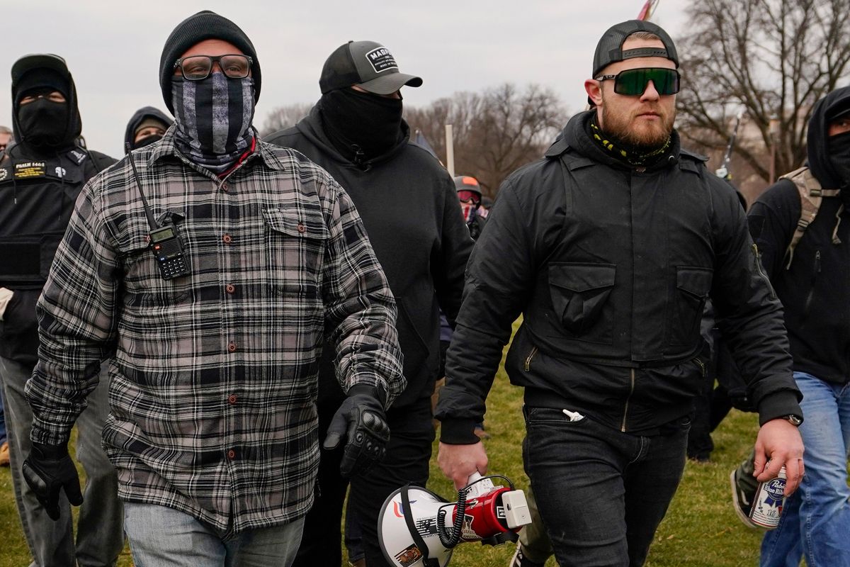 FILE - Proud Boys members Joseph Biggs, left, and Ethan Nordean, right with megaphone, walk toward the U.S. Capitol in Washington, Jan. 6, 2021. A federal judge on Tuesday, Dec. 28 refused to dismiss an indictment charging four alleged leaders of the far-right Proud Boys, Ethan Nordean, Joseph Biggs, Zachary Rehl and Charles Donohoe, with conspiring to attack the U.S. Capitol to stop Congress from certifying President Joe Biden