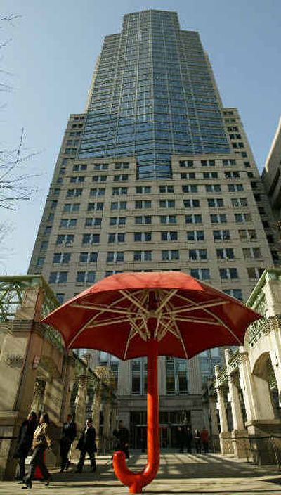 
Workers exit the Citigroup building passing by a large red Travelers umbrella Monday in New York. The insurance giant MetLife Inc. announced Monday that it was acquiring Travelers Life & Annuity Co. from Citigroup Inc. for at least $11.5 billion. 
 (Associated Press / The Spokesman-Review)