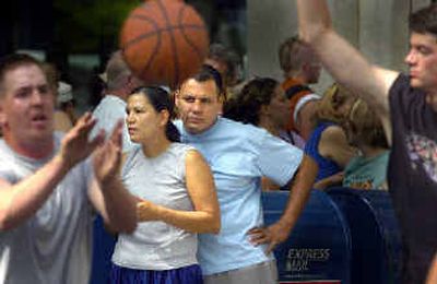 Virginia LeClere, left, and Roy Spoonhunter, right, watch some Hoopfest games as they await their game Saturday.
(Christopher Anderson/ / The Spokesman-Review)