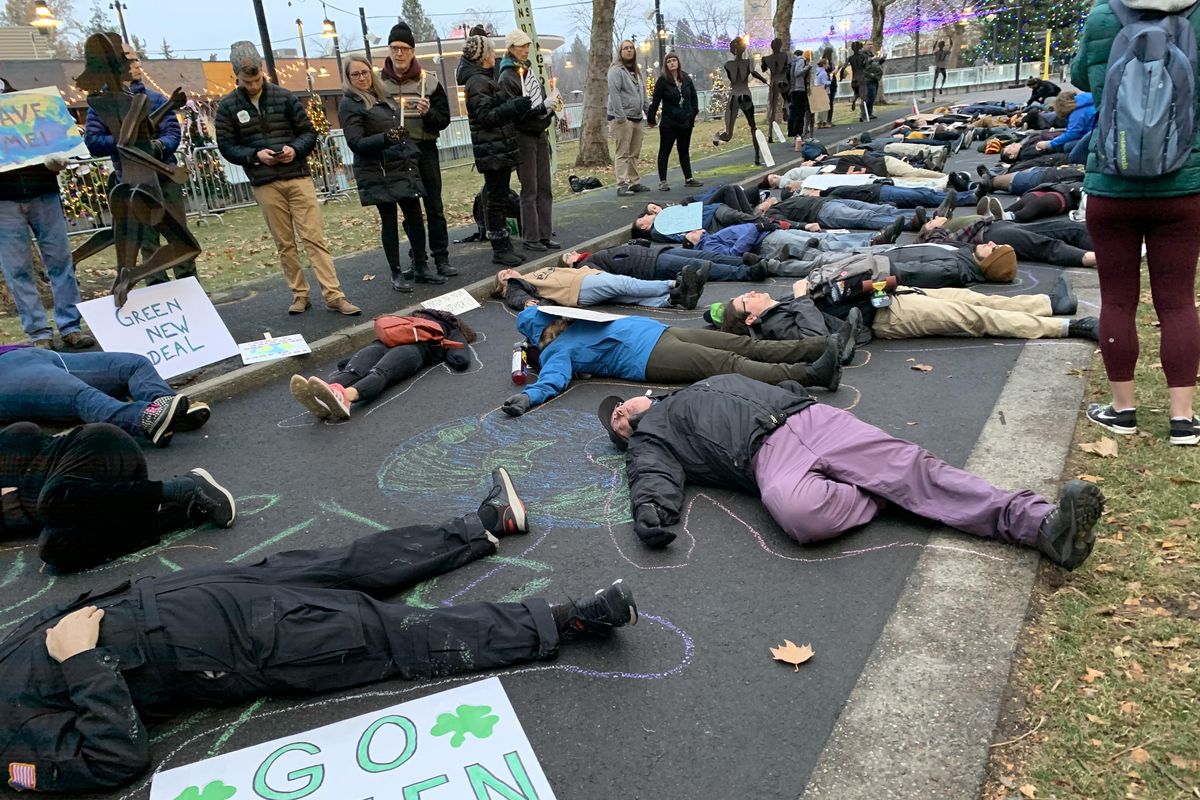 About 60 people “died” Friday afternoon in Spokane’s Riverfront Park to demand action on climate change from local elected officials. (Nicholas Deshais / The Spokesman-Review)