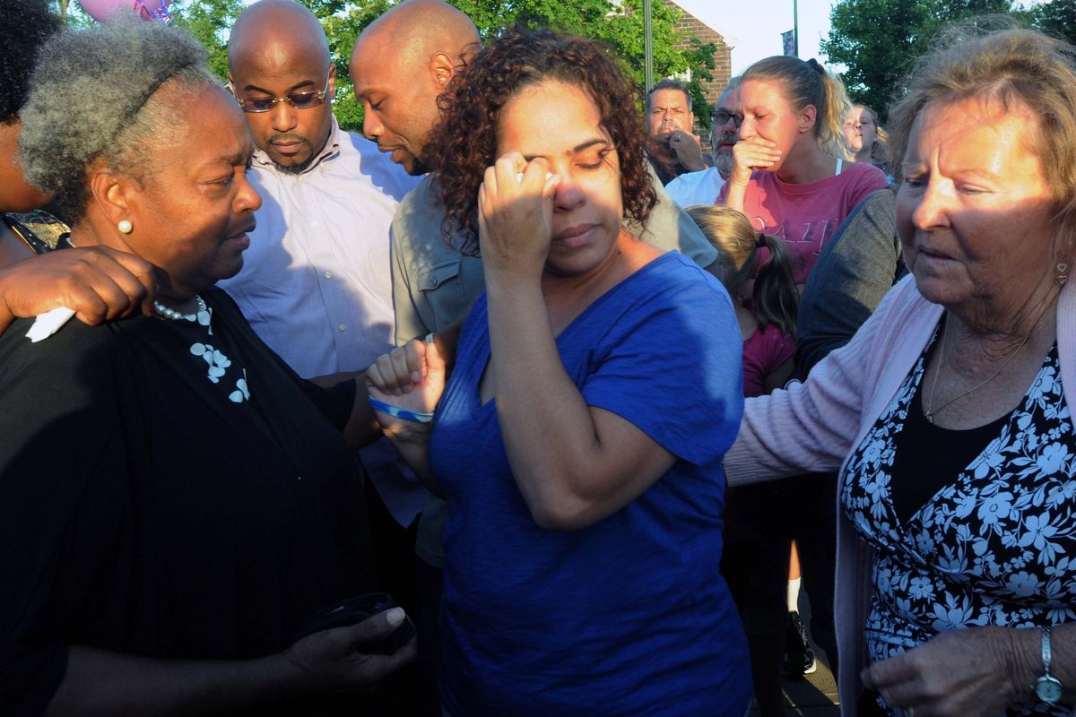 Joann Mitchell, center, mother of one of the plane crash victims, wipes away tears Saturday in East Haven, Conn. (Associated Press)