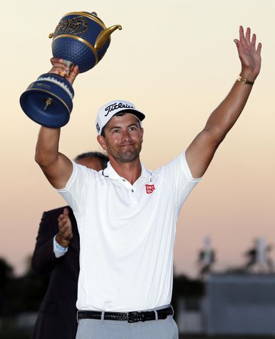 Adam Scott, of Australia, raises the Gene Sarazen Cup after winning the Cadillac Championship golf tournament Sunday in Doral, Florida. (Lynne Sladky / Associated Press)