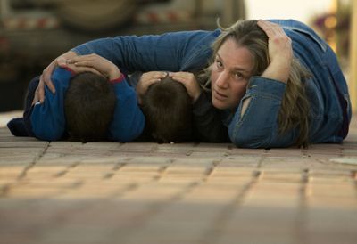 An Israeli woman  covers the heads of her children Wednesday during  an alarm warning of incoming rockets  in Kfar Azza, southern Israel, near the border with Gaza.  (Associated Press / The Spokesman-Review)