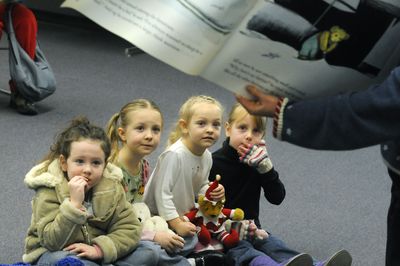 Talia Bender,  4, Elaine Scott,  5, Annie Scott,  4, and Elizabeth Matiska,  5, listen as  Jill Bolon, youth services coordinator at  Shadle  Library, reads  a story during  Teddy Bear Tea on Dec.  4.  (Dan Pelle / The Spokesman-Review)