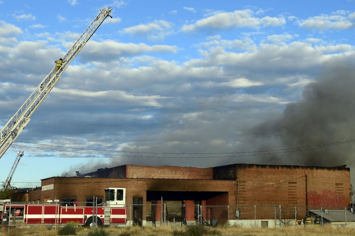 A fire at the abandoned former S&P Meats warehouse at 801 N. Regal St. burned through the night Sunday and into Monday morning. Spokane firefighters were keeping an eye on the fire since the building was not safe to enter. The smoke blanketed the neighborhood.  (Liz Kishimoto/The Spokesman-Review)