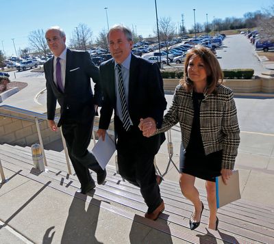 In this file photo, Texas Attorney General Ken Paxton, center, arrives at the Collin County Courthouse with his wife Angela, right, and attorney Phillip Hilder for his pretrial hearing Thursday, Feb. 16, 2017, in McKinney, Texas.  (Jae S. Lee/Dallas Morning News/TNS)