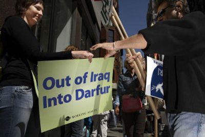 
Laura Cacho of Working Assets hands a protester a sign during a mass rally against the war in Iraq on Saturday in New York, NY. 
 (AP / The Spokesman-Review)