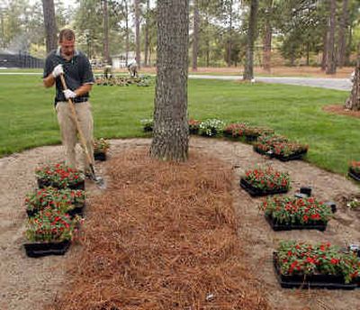 
Josh Gollnick, a member of the Pinehurst Resort Grounds Maintainance office, edges around pinestraw before planting fresh flowers.
 (Associated Press / The Spokesman-Review)