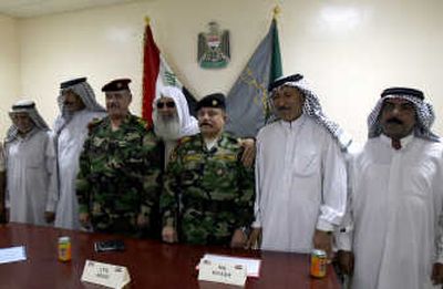 
Iraqi army Lt. Gen. Abboud Qanbar, third from left,  and Maj. Gen. Riyadh al-Qusaibi, third from right, stand with  five of the seven sheiks rescued Monday in Baghdad after their abduction Sunday. Associated Press
 (Associated Press / The Spokesman-Review)
