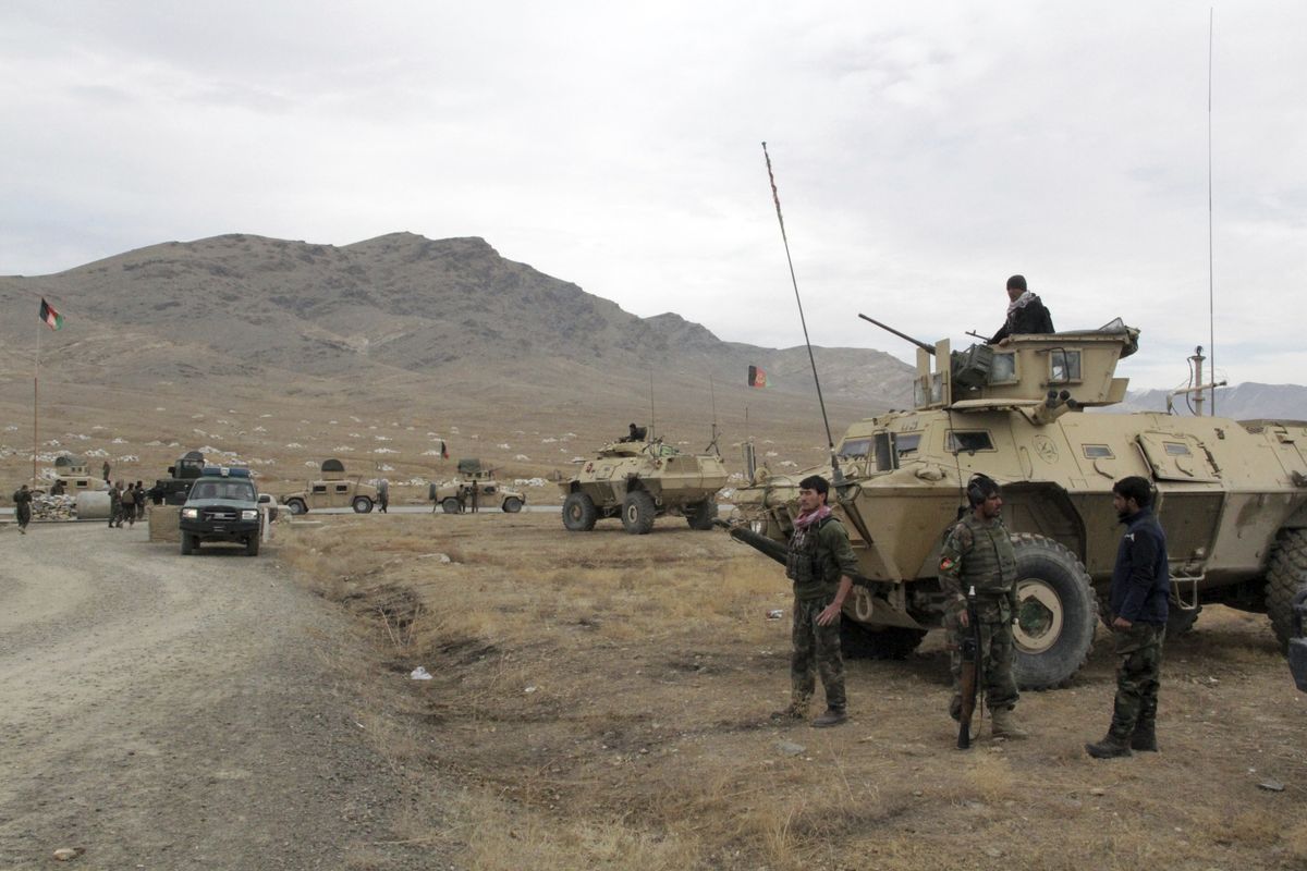 Afghan national army soldiers arrive at the site of a suicide bombing in Ghazni province west of Kabul, Afghanistan, Sunday, Nov. 29, 2020. Over 30 people were killed on Sunday in two separate suicide bombings in Afghanistan that targeted a military base and a provincial chief, officials said.  (Rahmatullah Nikzad)