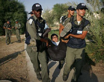 
Israeli policemen carry a Jewish settler from Netzarim in the Gaza Strip on Monday. Netzarim was the last of the 21 Gaza settlements to be evacuated by Israeli security forces. Its residents boarded armored buses and left for Israel after a farewell march behind Torah scrolls and a massive menorah.
 (The Spokesman-Review)