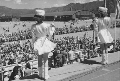 
On Aug. 2, 1942 nearly 25,000 people witnessed the ceremonies when the first of six units of Farragut Naval Training Station on Lake Pend Oreille was turned over to Lt. Com. H.G.Clark. Drum majorettes from Coeur d'Alene are seen in the foreground and behind the crowd is the mammoth drill hall.  
 (The Spokesman-Review)