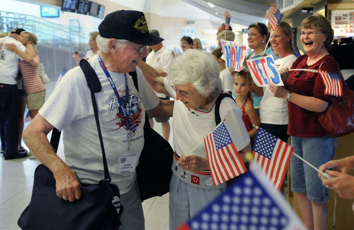 David Garinger is greeted by his wife, Zelma, and well-wishers at Spokane International Airport on Sunday, after Garinger and fellow World War II veteran Kenneth Hitchcock, far left, returned from a trip to the WWII Memorial in Washington D.C. sponsored by Honor Flight. (Dan Pelle / The Spokesman-Review)