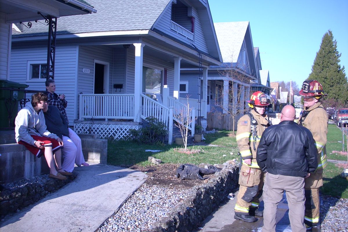 A 51-year-old Spokane woman was rescued April 16 from the second-floor balcony of her West Central home, 2317 W. Dean Ave., after fire broke out trapping her.

Spokane fire crews placed a ladder at the front of the home and helped the woman escape. 

A 16-year-old, at left, also escaped from the home. (Mike Prager / The Spokesman-Review)