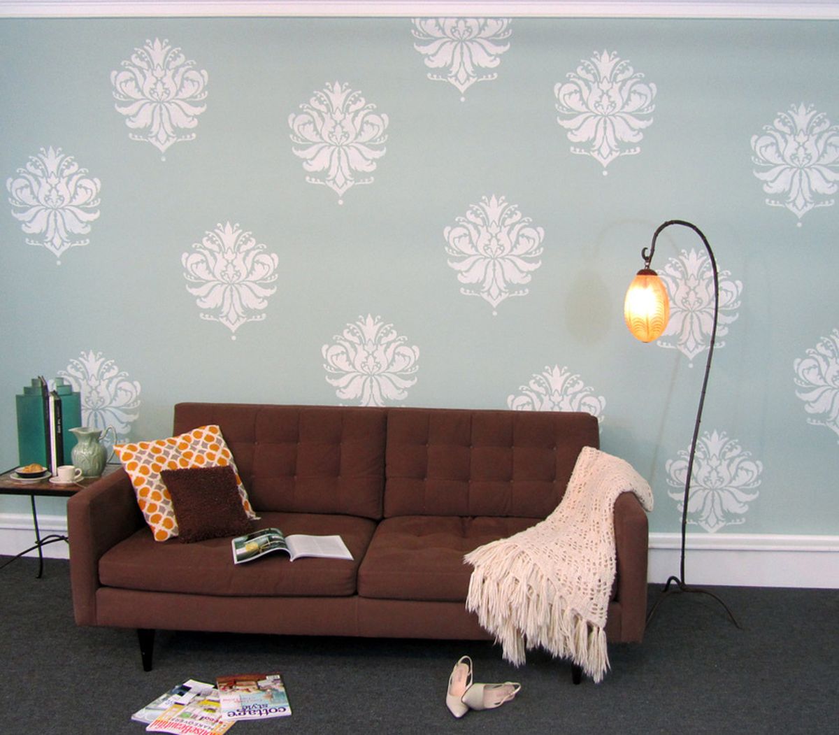 A room with Gabi’s Brocade stencil is shown on a living-room wall.