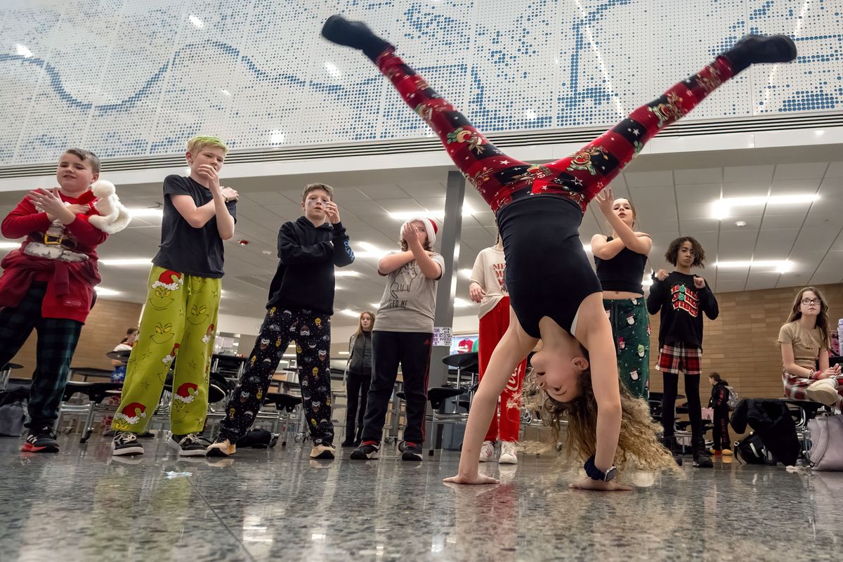 Kenzie Crane, 11, a sixth-grader at Flett Middle School, performs a cartwheel as fellow students dance to the song “Macarena” during a Friday lunchtime dance party. With cellphones banned at school, students now spend more time interacting. Flett was one the two middle schools that banned cellphones a year before the districtwide policy change.  (COLIN MULVANY/THE SPOKESMAN-REVIEW)