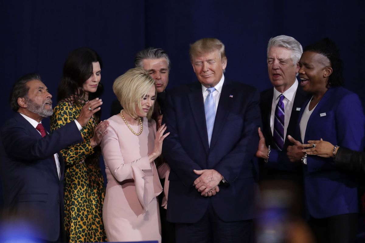 FILE - In this Friday, Jan. 3, 2020 file photo, faith leaders pray with President Donald Trump during a rally for evangelical supporters at the King Jesus International Ministry church in Miami. The conservative evangelical Christians who helped send Trump to the White House four years ago stuck by him again in 2020. But even if Trump doesn’t get a second term, some conservative Christians see reasons to celebrate in this year’s election results.  (Lynne Sladky)