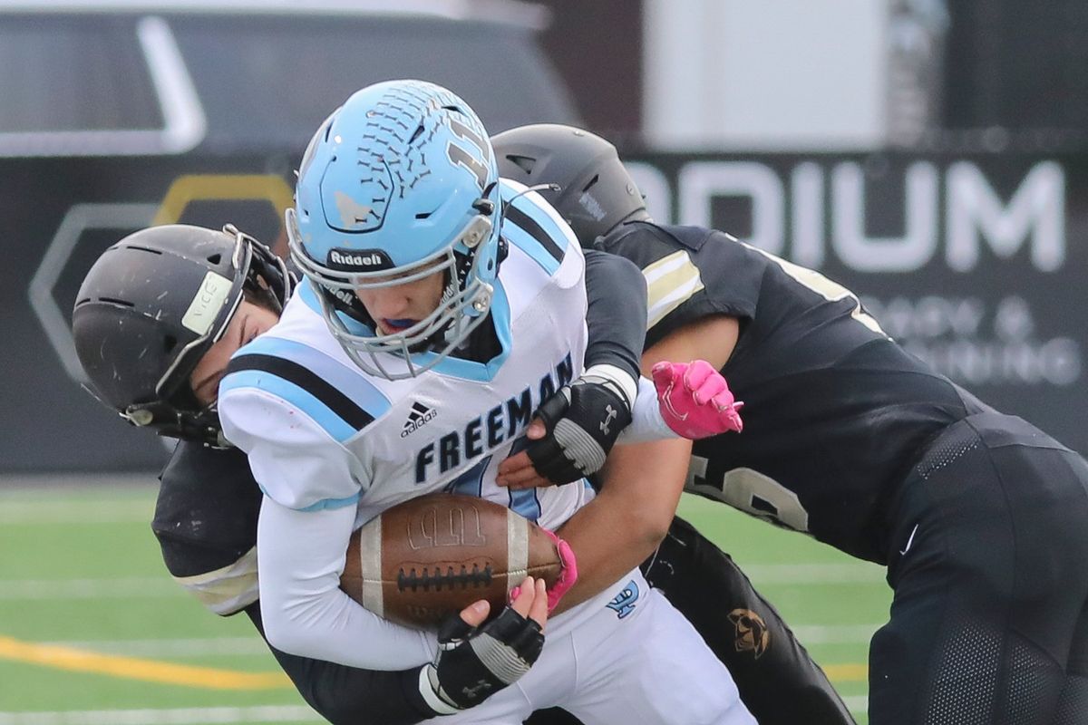 Freeman receiver Sage Gibert is smothered by a pair of Royal tacklers in a State 1A semifinal at Lions Field in Moses Lake on Saturday, Nov. 26, 2022.   (CHERYL NICHOLS/For The Spokesman-Review)