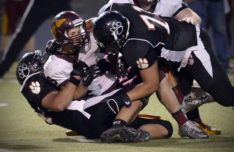 Moses Lake's Nathan Ball, center, is brought down by by Lewis and Clark's Noah Buckley, right, in the third quarter, Friday, Sept. 12, 2014, at Joe Albi Stadium. (Jesse Tinsley / The Spokesman-Review)