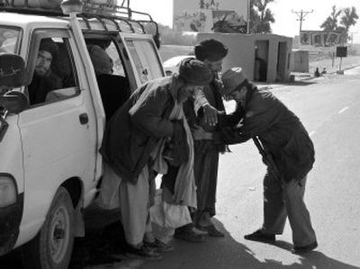 
An Afghan police officer checks passengers Tuesday as they enter Lashkar Gah, capital of Helmand province. 
 (Associated Press / The Spokesman-Review)