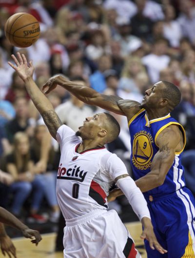 Trail Blazers’ Damian Lillard, left, shoots over Warriors’Andre Iguodala. (Craig Mitchelldyer / Associated Press)