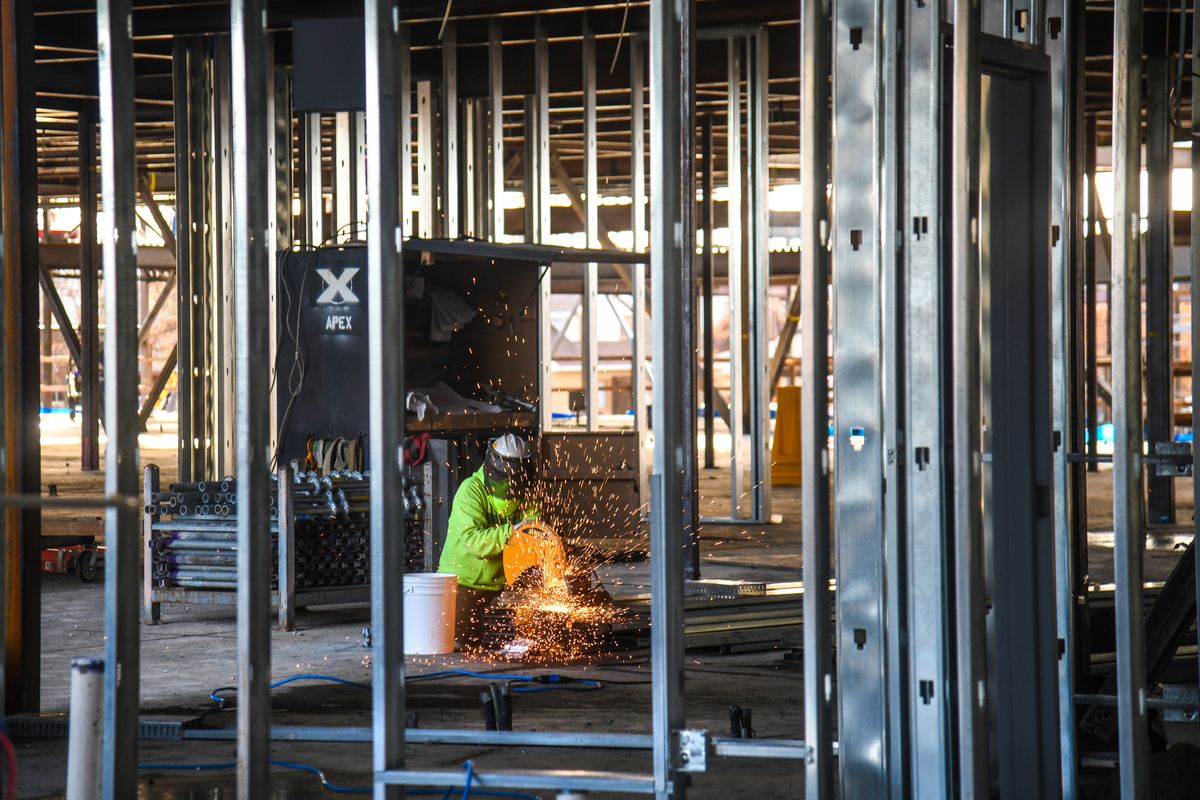 Bob Endicott, of LAC Drywall, cuts metal strips in the library area of the new Glover Middle School, Friday, Nov. 20, 2020, in Spokane.  (DAN PELLE/THE SPOKESMAN-REVIEW)