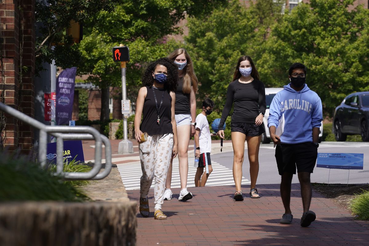 FILE - In this Aug. 18, 2020, file photo, students wear masks on campus at the University of North Carolina in Chapel Hill, N.C. As more and more schools and businesses around the country get the OK to reopen, some college towns are moving in the opposite direction because of too much partying and too many COVID-19 infections among students. (Gerry Broome)