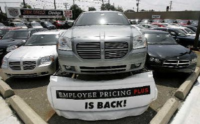 
An employee pricing plus sign is shown at a Dodge dealership in Dearborn, Mich., on Friday.  
 (Associated Press / The Spokesman-Review)