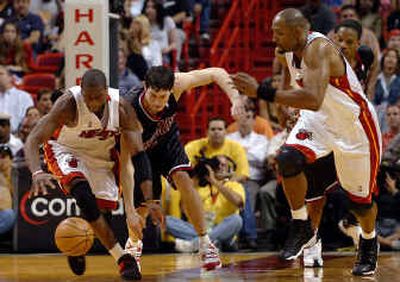 
Miami guard Dwyane Wade, left, and Chicago guard Kirk Hinrich chase after a loose ball as Miami center Alonzo Mourning heads down court.
 (Associated Press / The Spokesman-Review)