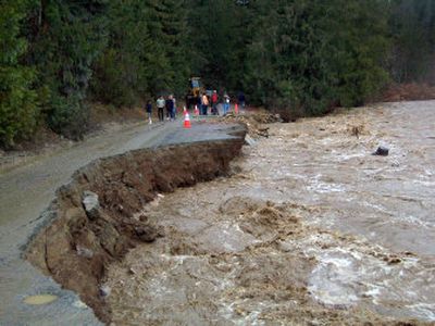 
Spring Creek Road in Clark Fork, Idaho, washed out. It took the phone lines with it, and exposed the city's water line. Crews are dumping rock in an effort to stabilize the banks. 
 (Trish Gannon Special to / The Spokesman-Review)
