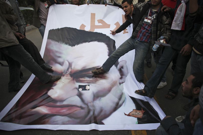Anti-government protesters stamp on a poster of Egyptian President Hosni Mubarak as they pose for a photo outside the Egyptian Parliament in Cairo on Wednesday. (Associated Press)