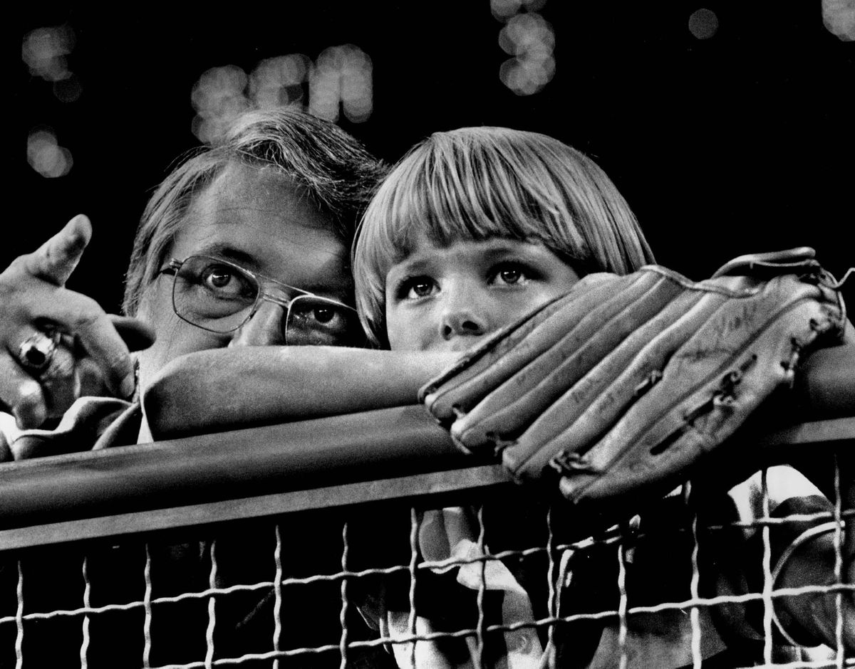 Robert Schober, of Mercer Island, explained some of the fine points of baseball to his son, Willie, 8, during a Seattle Mariners game in the Kingdome. Willie had come prepared to field and foul balls that might come his way. (Dale Blindheim/Seattle Times)