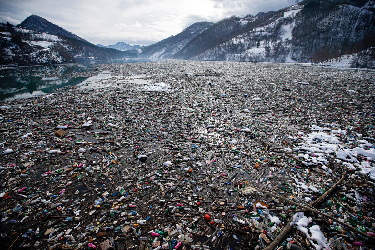 FILE - Plastic bottles and other garbage float in Potpecko lake near Priboj, in southwest Serbia on Jan. 22, 2021. The U.N. Environment Assembly (UNEA) unanimously voted Wednesday, March 2, 2022 in Nairobi, Kenya to start to create a legally binding global treaty to address plastic pollution in the world