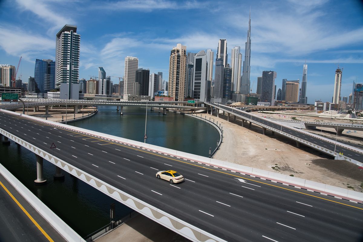 In this April 6, 2020, file photo, a lone taxi cab drives over a highway in front of the Dubai skyline. The United Arab Emirates announced on Saturday a major overhaul of the country’s Islamic personal laws, allowing unmarried couples to cohabitate, loosening alcohol restrictions and criminalizing so-called “honor killings.”  (Jon Gambrell)